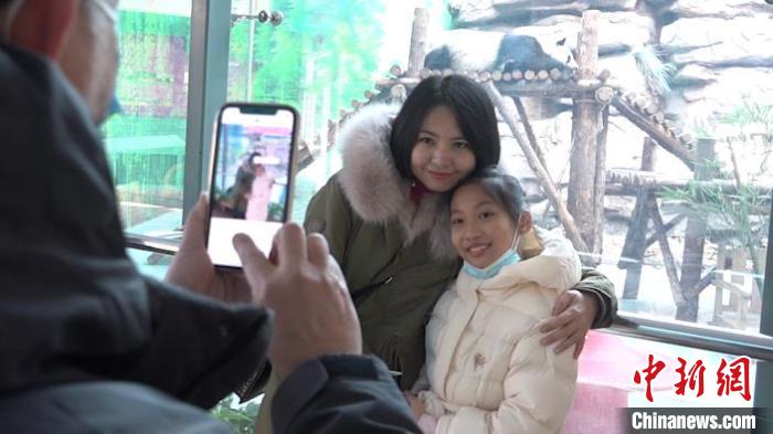圖為在週末抽出時間看大熊貓的鄭景文一家人，鄭景文正在為愛人和女兒拍照。　馬知遠 攝